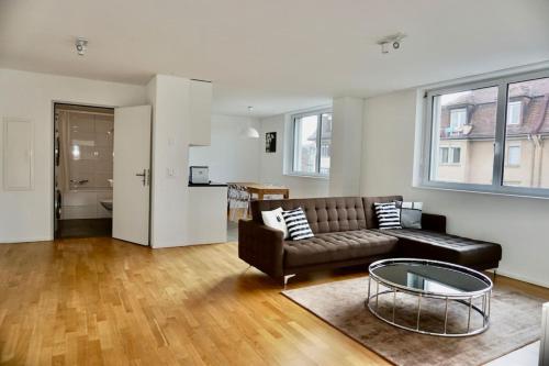 ein Wohnzimmer mit einem Sofa und einem Tisch in der Unterkunft Balcony Suite in Central Zurich SH2,4R in Zürich