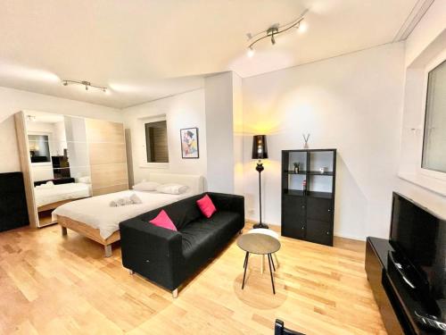 Un dormitorio con una cama, un sofá y un televisor. en Zurich City Dream Studio SH04L, en Zúrich