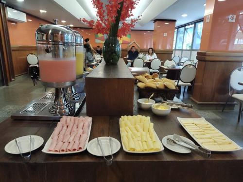 un tavolo con piatti di formaggio e un frullatore di Hotel Oscar Gold Savassi a Belo Horizonte