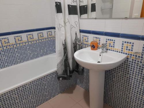 een badkamer met een witte wastafel en een bad bij Apto. Dunas Playa in Isla Cristina