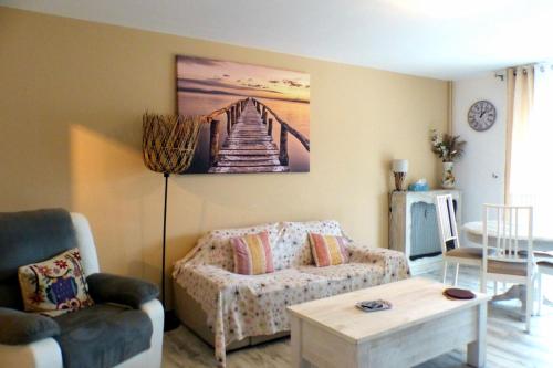 een woonkamer met een bank en een schilderij van een brug bij Beautiful apartment located 800 m from the Beach in Six-Fours-les-Plages