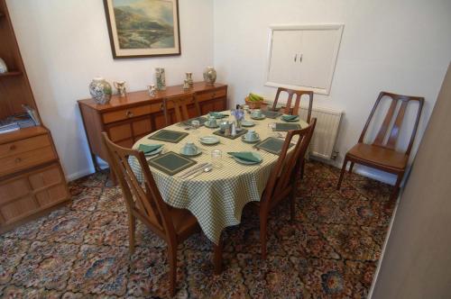 uma sala de jantar com uma mesa com cadeiras e uma toalha de mesa em Dwy Olwyn em Dolgellau