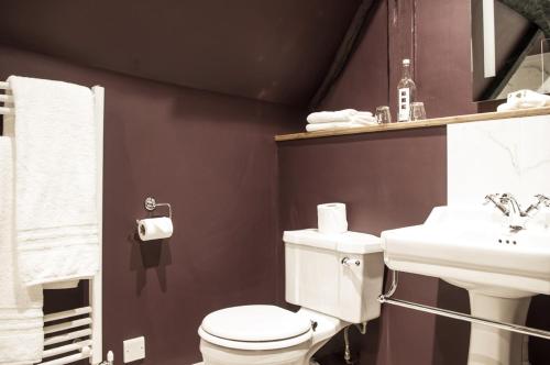 a bathroom with a white toilet and a sink at The Greyhound Inn in Wantage