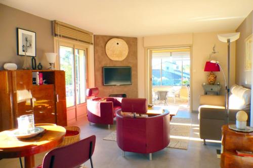 un salon avec des chaises rouges et un canapé dans l'établissement Nice house with private pool, à Sanary-sur-Mer
