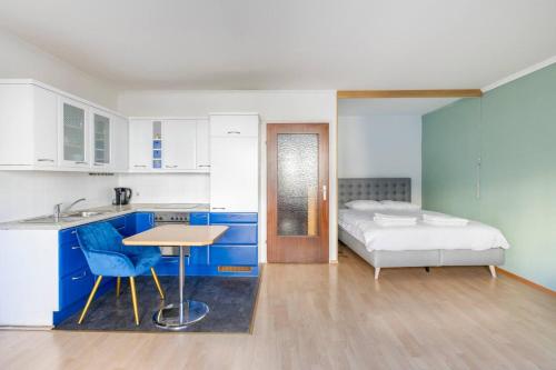 - une cuisine avec des placards bleus et un lit dans une chambre dans l'établissement K&K Apartments Schönbrunn - Kingsize Bed & Netflix Self Check-In, à Vienne