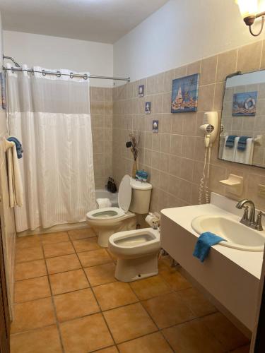 a bathroom with two toilets and a sink and a shower at Paradise Island in Isabela