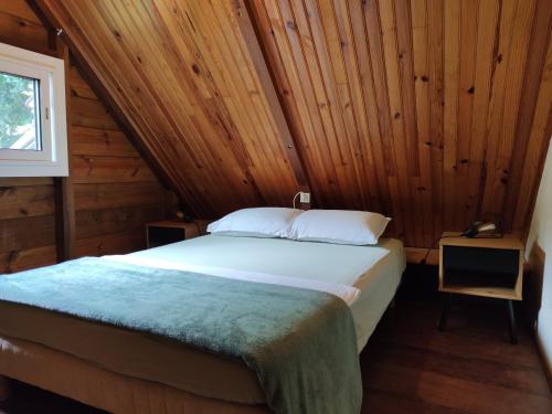 a bedroom with a bed in a wooden cabin at Ti Palissandre in LʼEntre-Deux