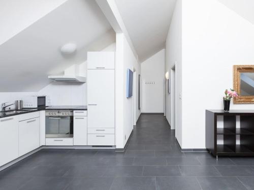 eine Küche mit weißen Schränken und Fliesenboden in der Unterkunft Sunrise Terrace 2,5 Room Apartment FR-31 in Wallisellen