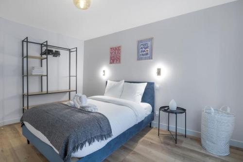 - une chambre avec un lit bleu et blanc et 2 tables dans l'établissement 3 Cozy apartments near Galeries Lafayette-12Pers, à Paris