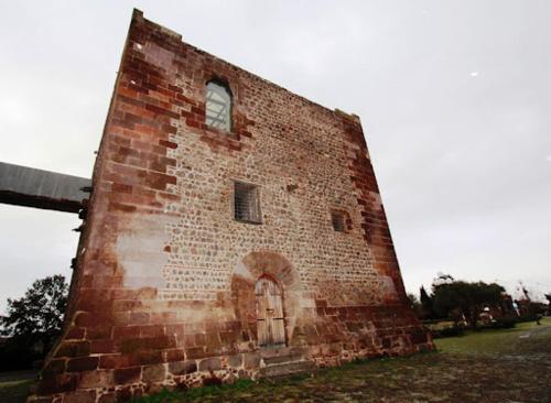 a tall brick building with a window and a door at Anninnìa Guest House B&B - GhiIarza in Ghilarza