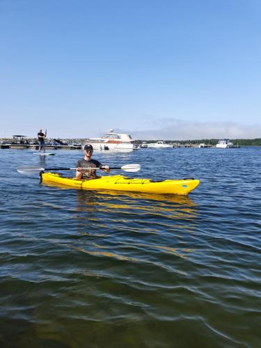 a man in a yellow kayak in the water at Epokgården in Öregrund