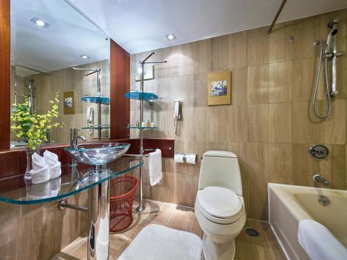 La salle de bains est pourvue d'un lavabo, de toilettes et d'une baignoire. dans l'établissement Hongqiao Jin Jiang Hotel (Formerly Sheraton Shanghai Hongqiao Hotel), à Shanghai