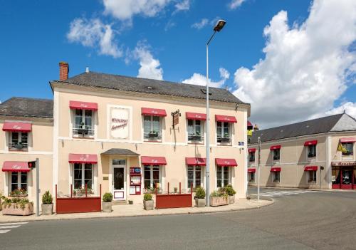 une rue vide en face d'un bâtiment avec des auvents rouges dans l'établissement Logis La Renaissance, au Lude