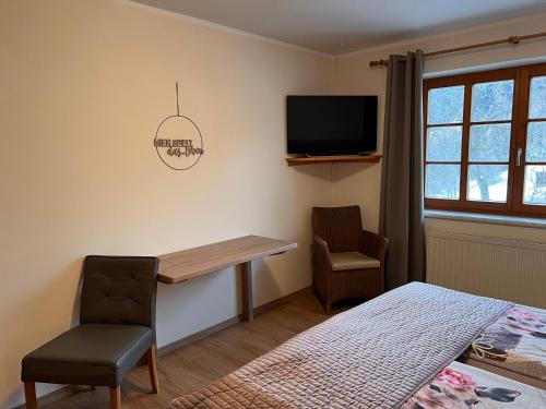 a bedroom with a desk and a bed and a tv at Landhaus Aigner in Allhartsberg