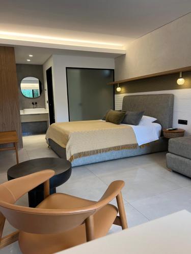 a bedroom with a large bed and a chair at Charisma Boutique Hotel in Parga