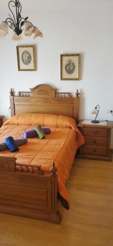 1 dormitorio con 1 cama de madera y 2 almohadas en HOGAREÑO ADOSADO EN EL PUEBLO DE ARDALES, en Ardales