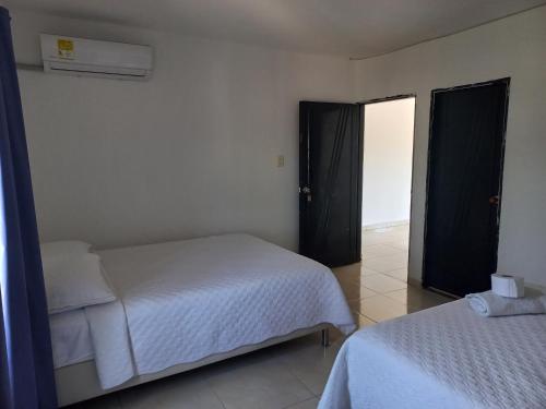 a bedroom with two beds and two open doors at Hotel Samark Valledupar in Valledupar