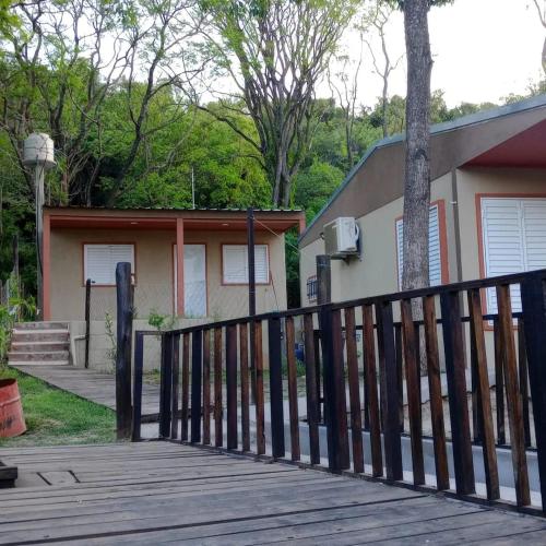 Ein Haus mit einer Holzterrasse und einem Haus in der Unterkunft Los Lapachos in Oro Verde