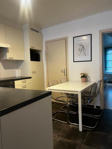 una cucina con tavolo e sedie bianchi di Anna Flat a Gand