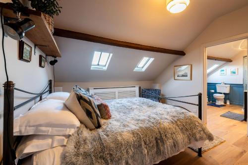 a bedroom with a bed in a room with skylights at Stable Cottage in Teffont Magna