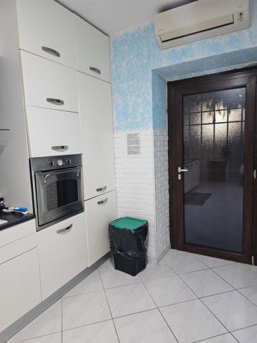 a kitchen with a door and a microwave at Appartamento sofí in Fiumicino