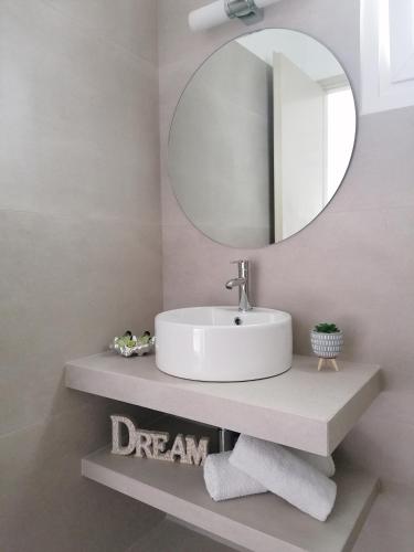 a bathroom with a white sink and a mirror at Eleni Dream Village in Parikia