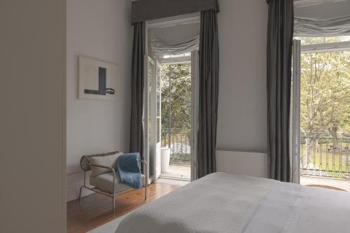a bedroom with a bed and a chair and a window at Oporto Loft in Porto