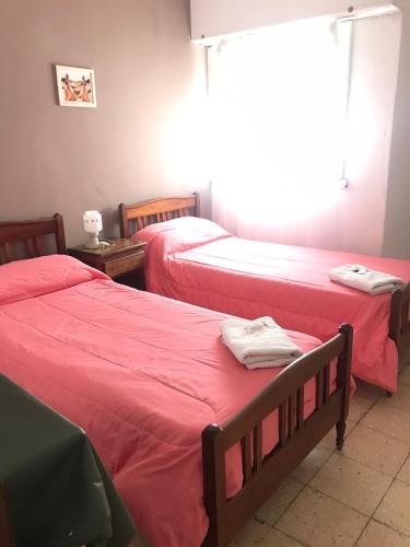 two beds in a room with red sheets at Hotel Embassy in Miramar