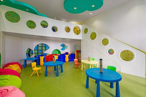 a room with blue tables and colorful chairs at TUI BLUE Nha Trang in Nha Trang