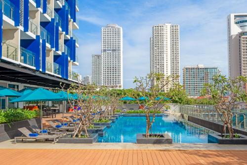 a pool in the middle of a city with tall buildings at TUI BLUE Nha Trang in Nha Trang