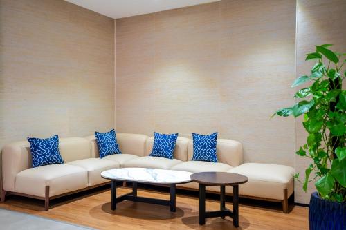 a living room with a white couch and blue pillows at TUI BLUE Nha Trang in Nha Trang