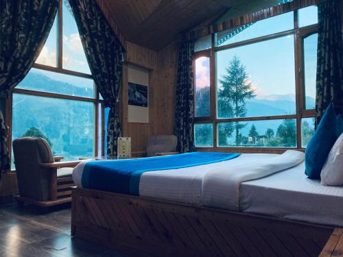 a bedroom with a bed in a room with windows at Woods Villa Cottage, Manali in Manāli