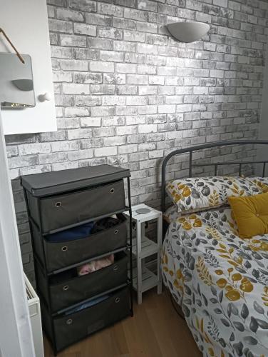 een slaapkamer met een zwarte dressoir en een bakstenen muur bij Berwick upon Tweed flat in Berwick-Upon-Tweed