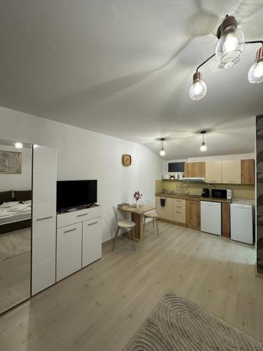 een grote keuken met witte kasten en een tafel bij Jokai Apartments Nr8, code entry in Sfântu-Gheorghe