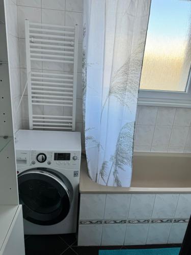 a washing machine in a bathroom with a window at Apartment C25 in Trnava