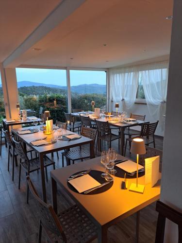 a restaurant with tables and chairs and a large window at Tenuta di Forte Sorgnano in Gualdo Cattaneo