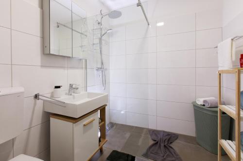 a white bathroom with a sink and a shower at Wohlfühlapartment 47 in Götzis