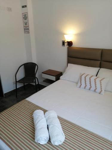 a bedroom with a bed with two towels on it at Casa Yuraq Hotel Boutique in Chincha Alta