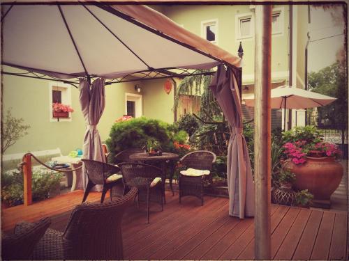 an outdoor deck with a table and chairs and an umbrella at Hostel Sonce in Ptuj