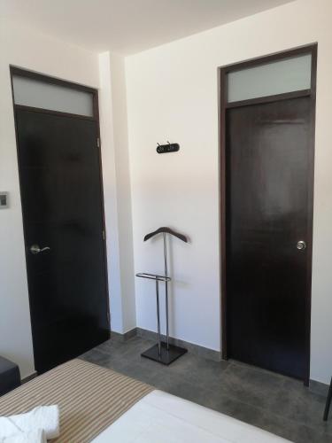 two black doors in a room with a bed at Casa Yuraq Hotel Boutique in Chincha Alta