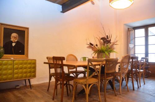 a dining room with a table and a painting of a man at Casa Sapita in Villafranca del Bierzo