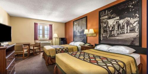 a hotel room with two beds and a flat screen tv at Super 8 by Wyndham New Orleans in New Orleans