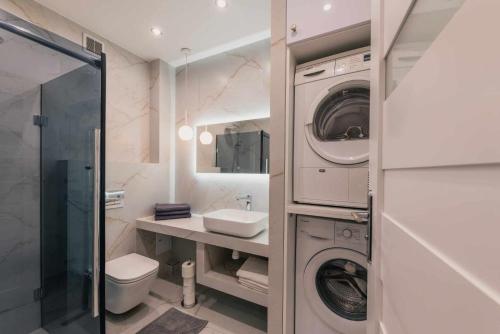 a white bathroom with a washer and dryer in it at Apartament Pod 13 in Bielsko-Biała