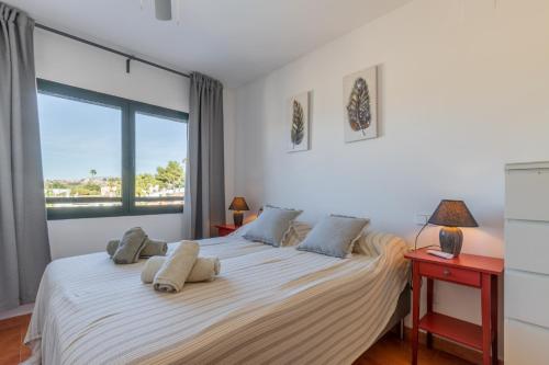 - une chambre avec un grand lit blanc et une fenêtre dans l'établissement Dimora Floriana by Sun & Sea Homes, à Moraira
