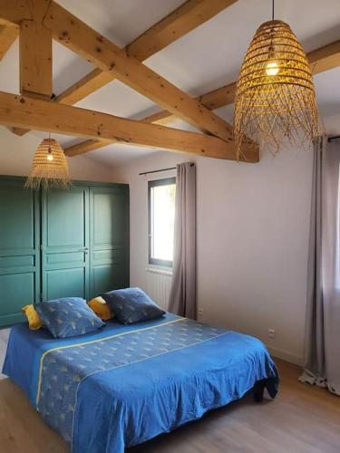 - une chambre avec un lit bleu et 2 oreillers dans l'établissement Un écrin à Cornillon en Provence, à Cornillon-Confoux