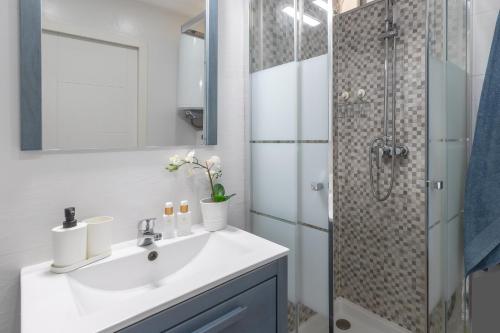 a white bathroom with a sink and a shower at Apartamento costa del Sol in Benalmádena