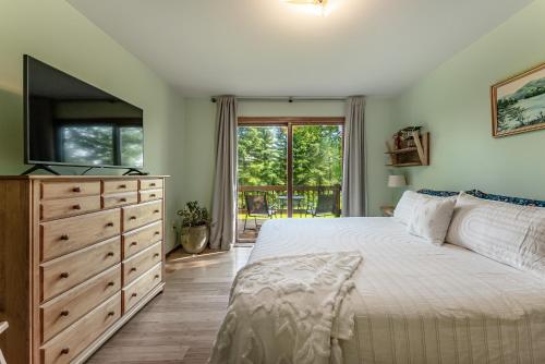 1 dormitorio con 1 cama y vestidor con TV en Mountain Escape: with Sauna near Yellowstone en Bozeman