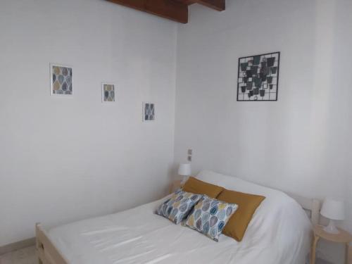 un lit blanc avec deux oreillers dessus dans l'établissement Les Girelles - T2, 50m2 avec vue sur canal, à Palavas-les-Flots