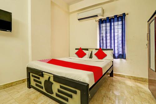 um quarto com uma cama com almofadas vermelhas em OYO ROYAL HAVEN em Hyderabad