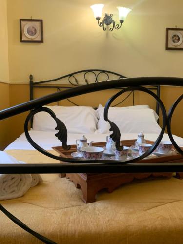 a bed with a black iron bed frame and a table at Hotel PIGNATELLI Napoli in Naples